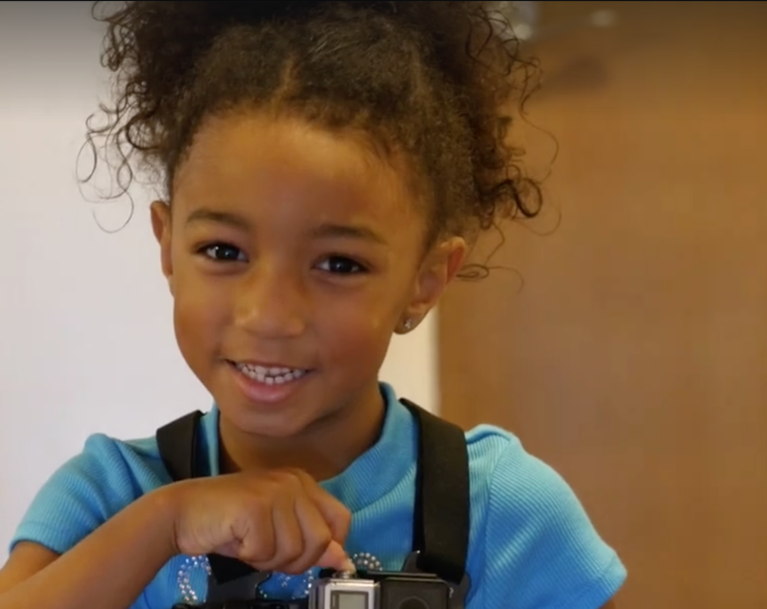 Com câmera fotográfica, menina registra seu primeiro dia de aula no jardim de infância
